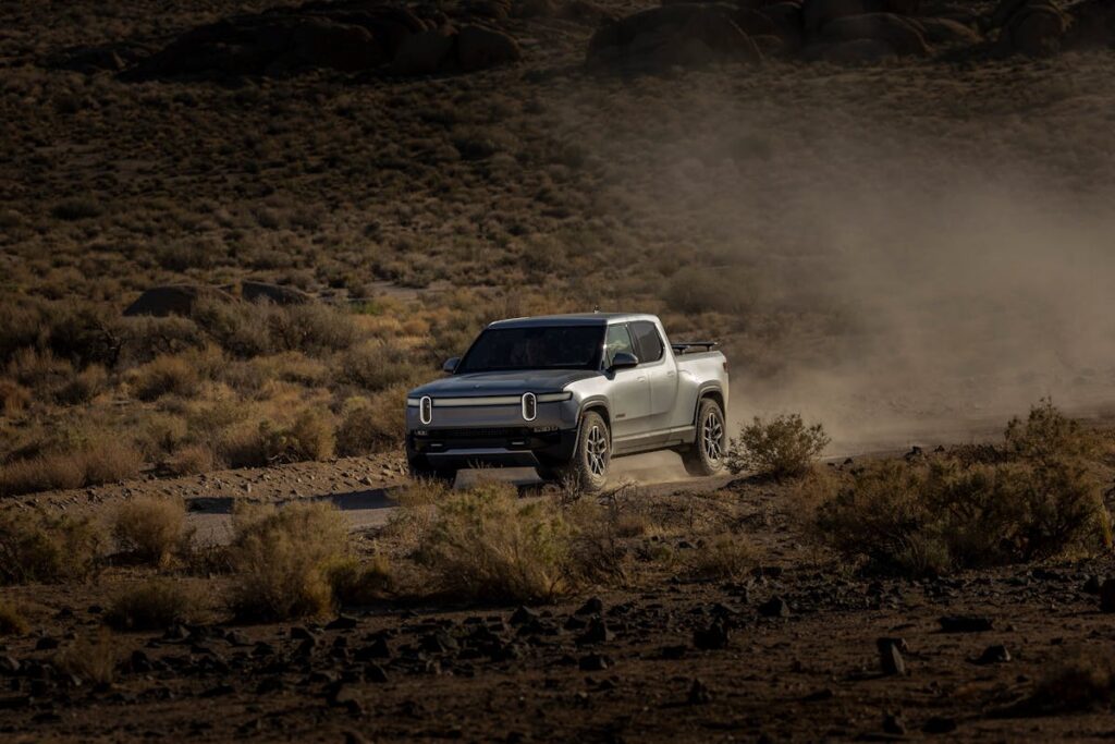 Electric Pickup Truck Driving in Desert Landscape