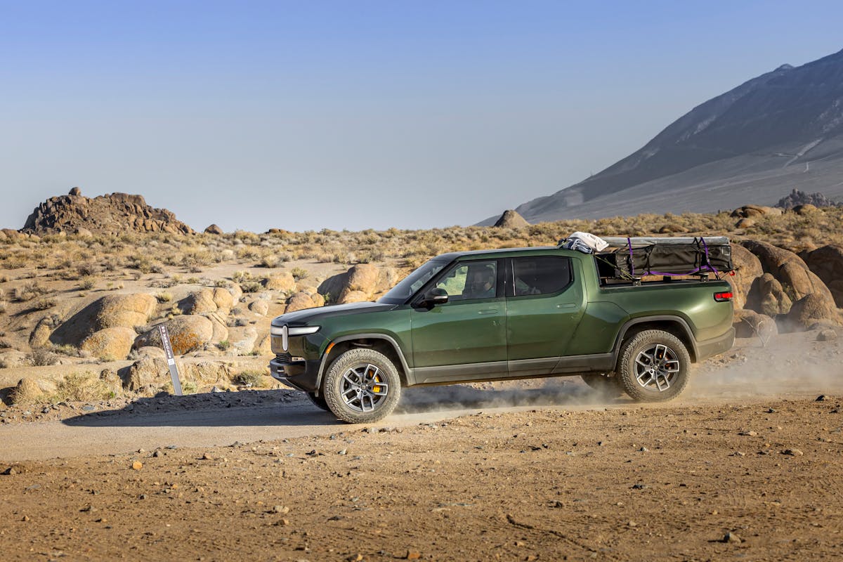 Green Pickup Truck Driving in Desert Landscape